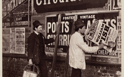 A vintage street advertising scene with posters being pasted